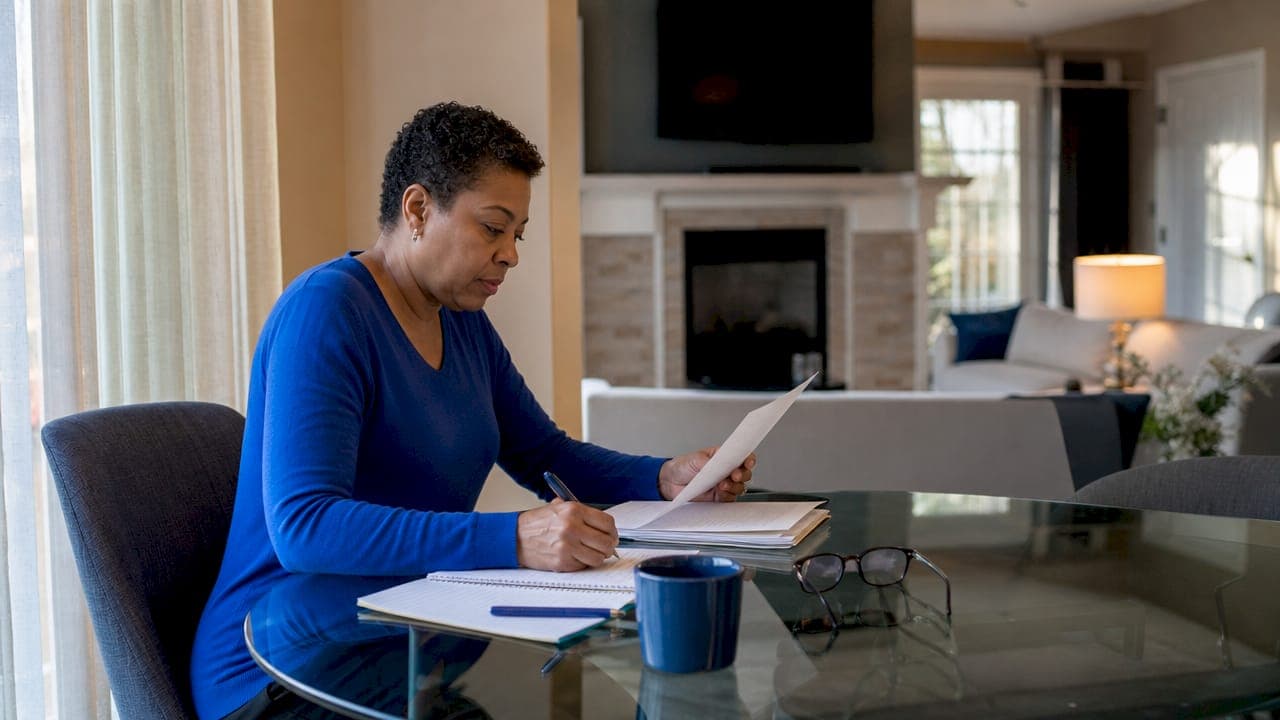 Homeowner reviewing a real estate offer at kitchen table