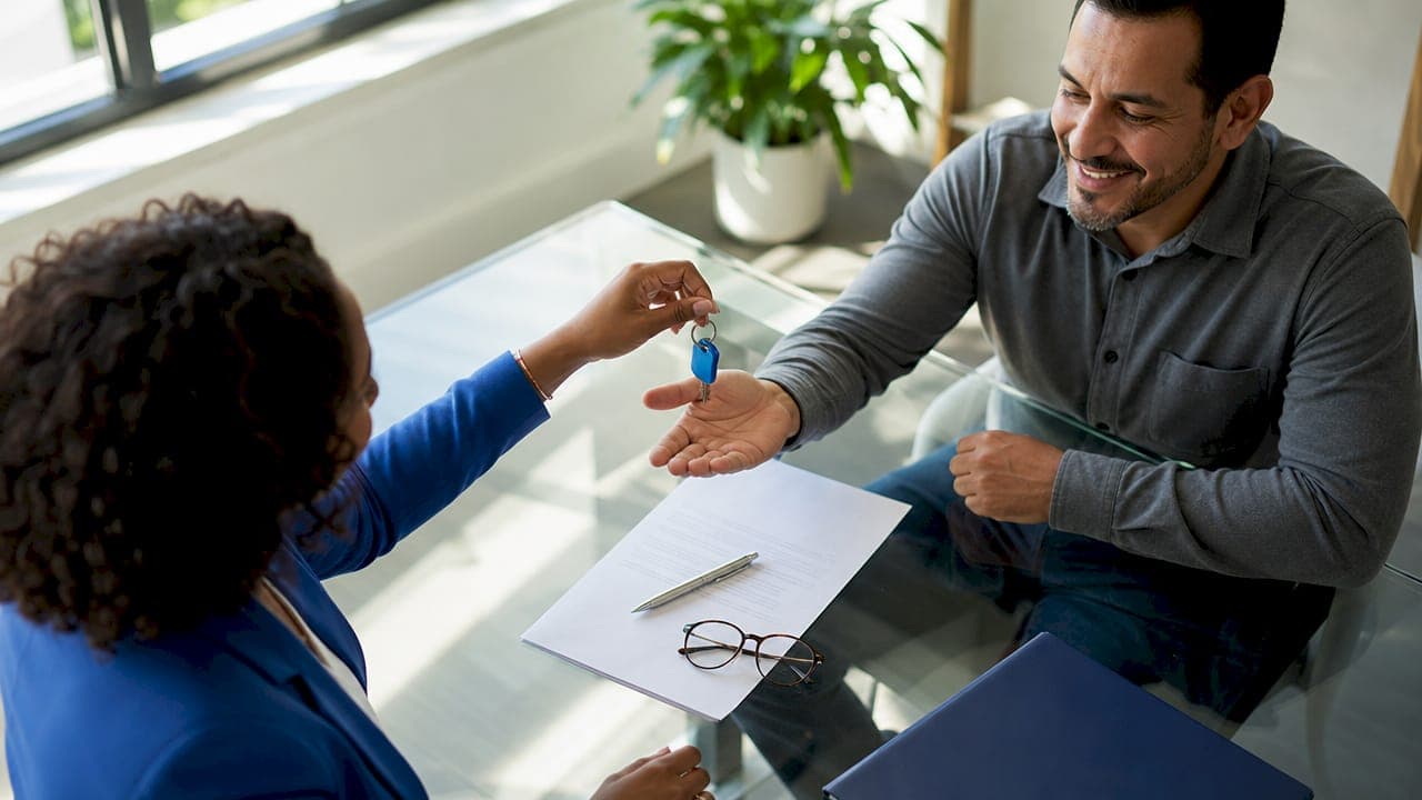 Hands exchanging keys over contract